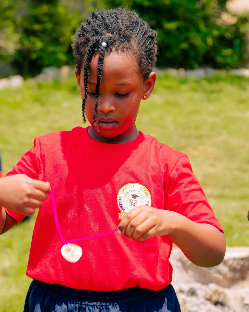 A girl concentrating on a spinning toy made from string
