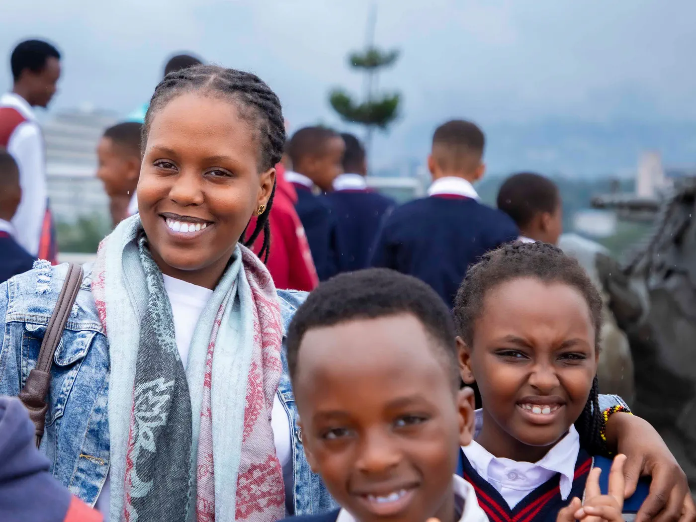 A teacher smiling with two of her pupils on a school trip
