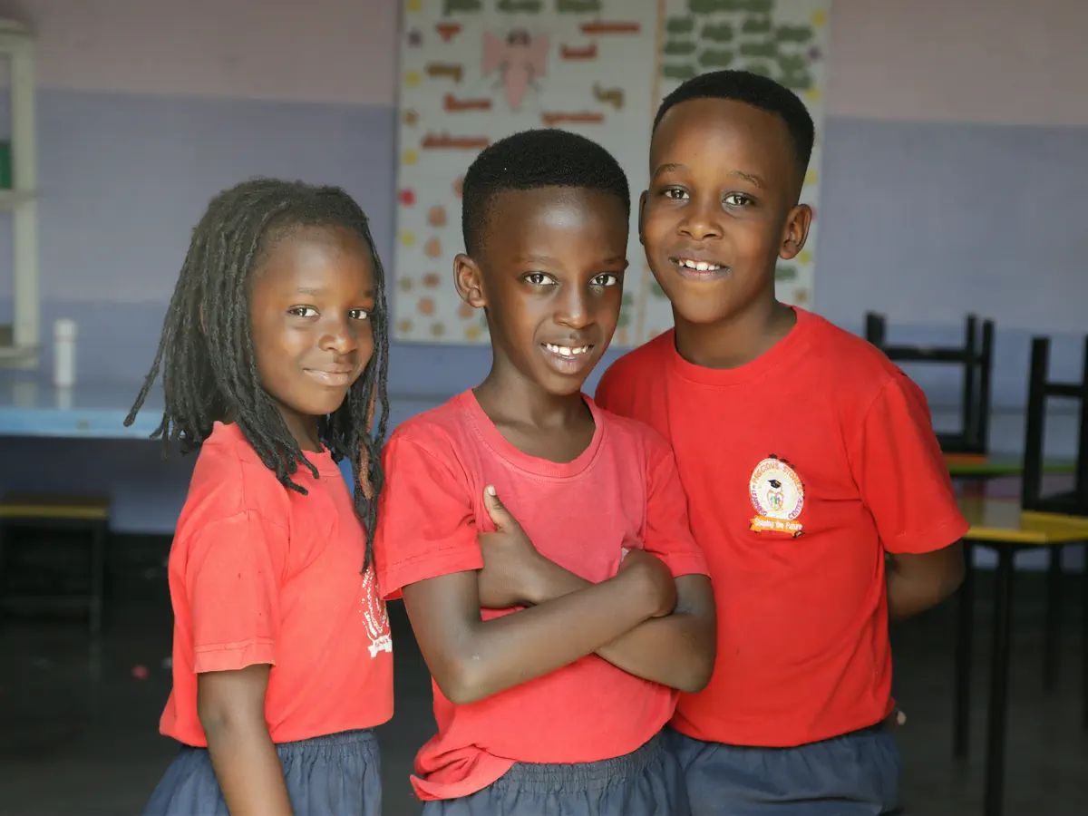 Three primary pupils smiling in their classroom