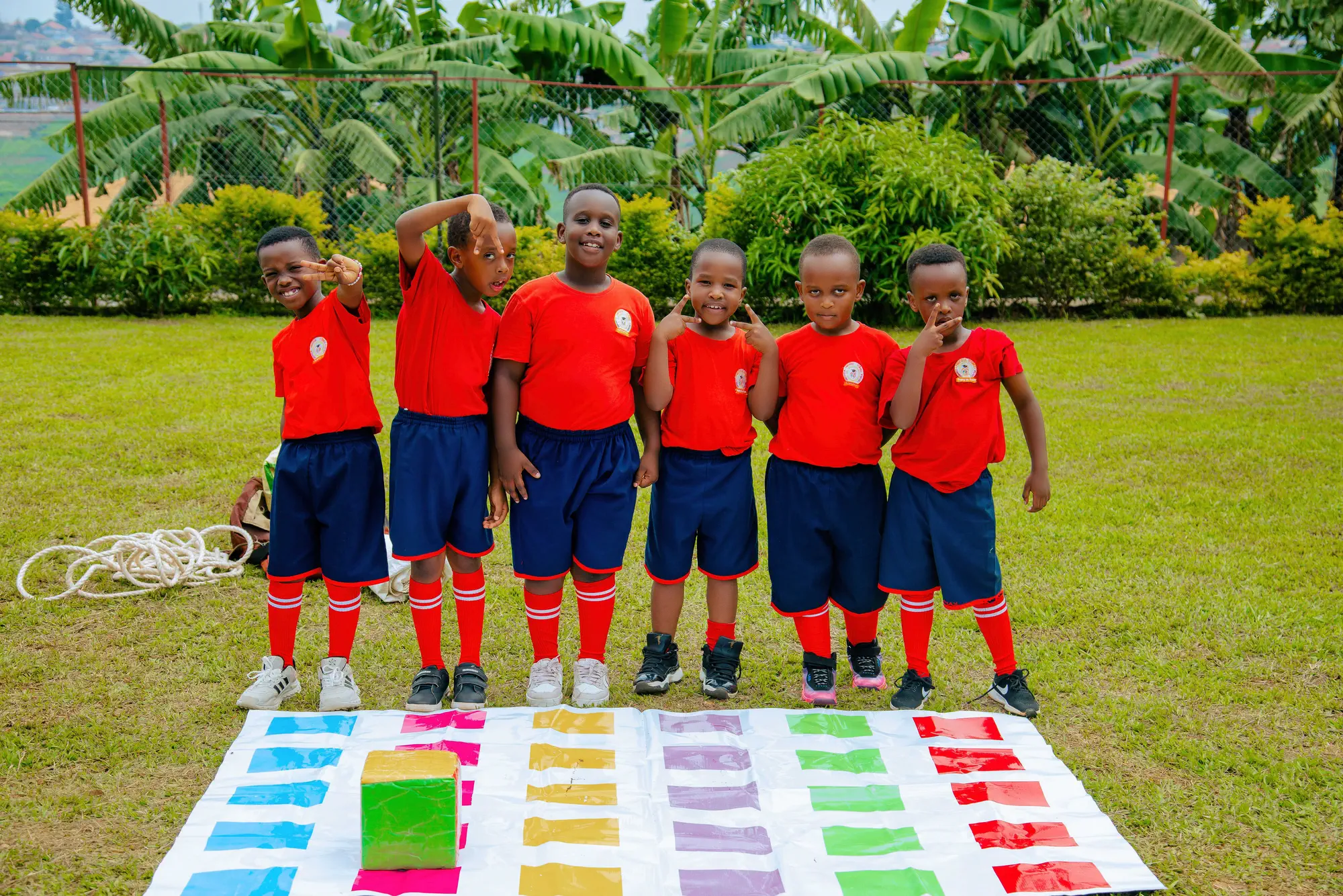 Six pupils in uniform standing together and smiling on the school lawn